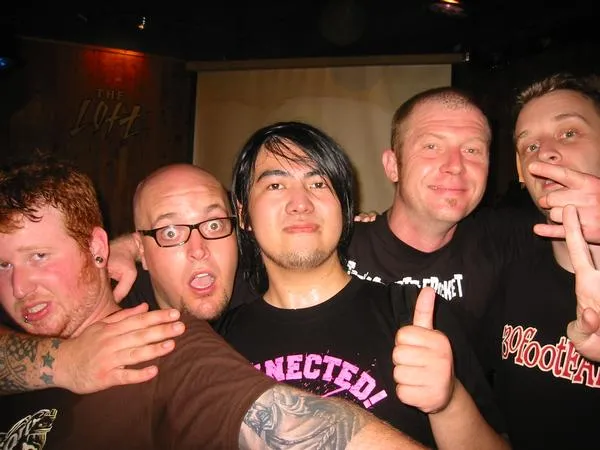 SecondShot members posing with a friend after a show, one giving a thumbs up